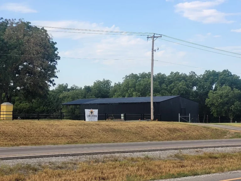 Longhorn Landing RV Park sign on a black barn, visible from Hwy 70