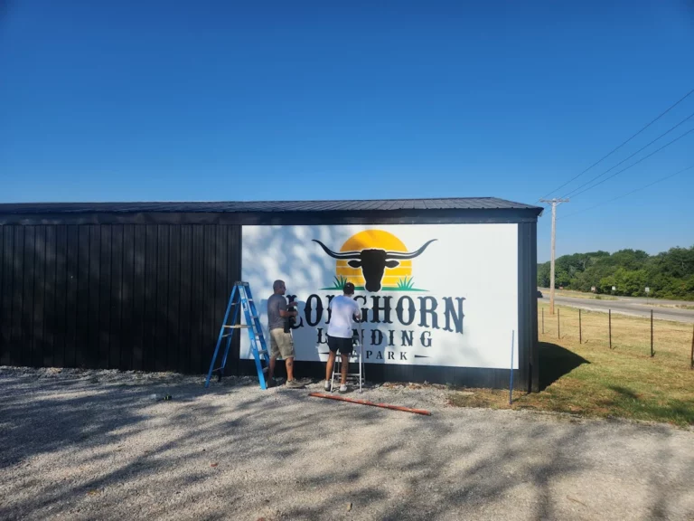 Installing the Longhorn Landing RV Park sign on the park's black barn